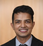 man brown hair smiling for headshot